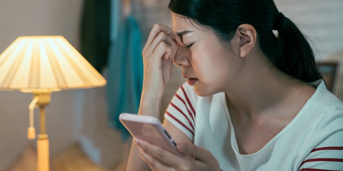 スマホの使い過ぎで目の疲れを感じている女性